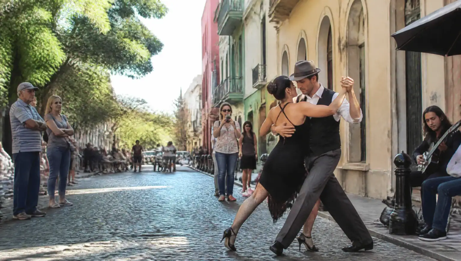 Calle empedrada de San Telmo con edificios coloniales y bailarines de tango, a poca distancia del aeropuerto de Ezeiza