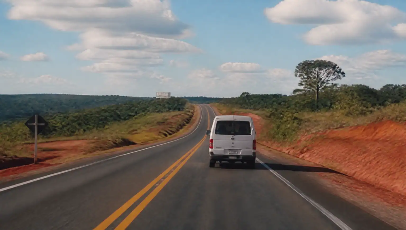 Ruta por el campo paraguayo con tierra colorada rumbo a Asunción desde Puerto Iguazú