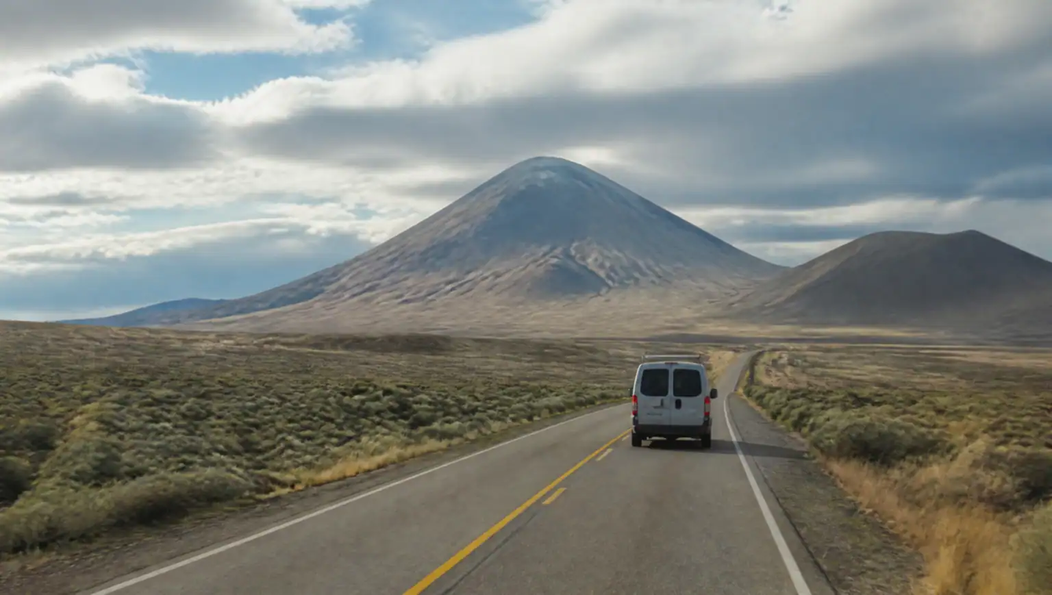 Ruta por la estepa patagónica y cerros volcánicos cerca de Zapala, Neuquén, vistos desde una camioneta