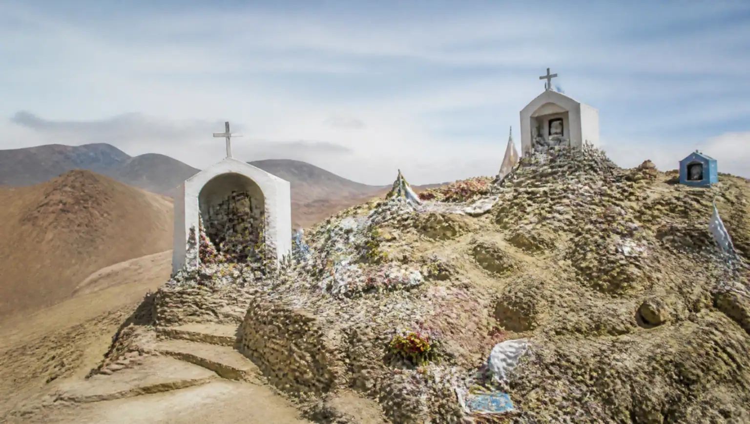 Pilgrimage sanctuary with small chapels and offerings on a desert hillside at Vallecito, near San Juan, Argentina